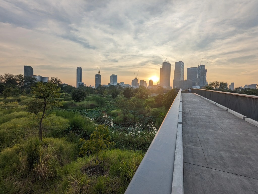 Benjakitti Park in Bangkok in der Abenddämmerung mit seiner spektulären Aussicht auf Natur, Brücken und Skyline zum Joggen oder spazieren gehen