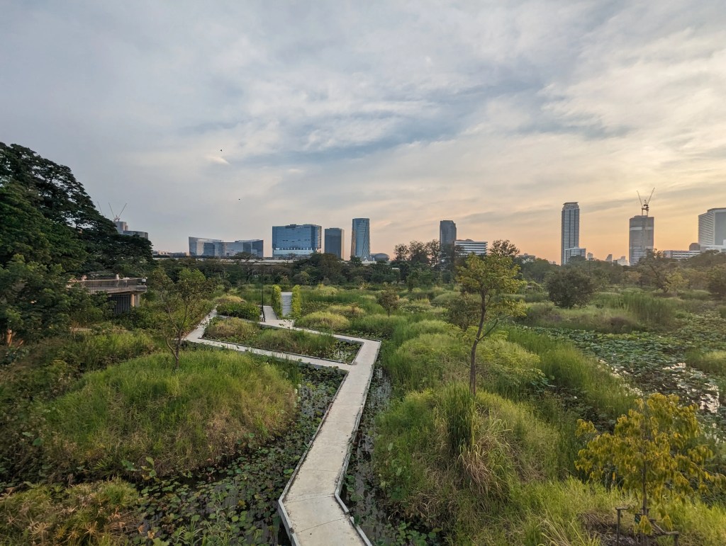 Benjakitti Park in Bangkok in der Abenddämmerung mit seiner spektulären Aussicht auf Natur, Brücken und Skyline