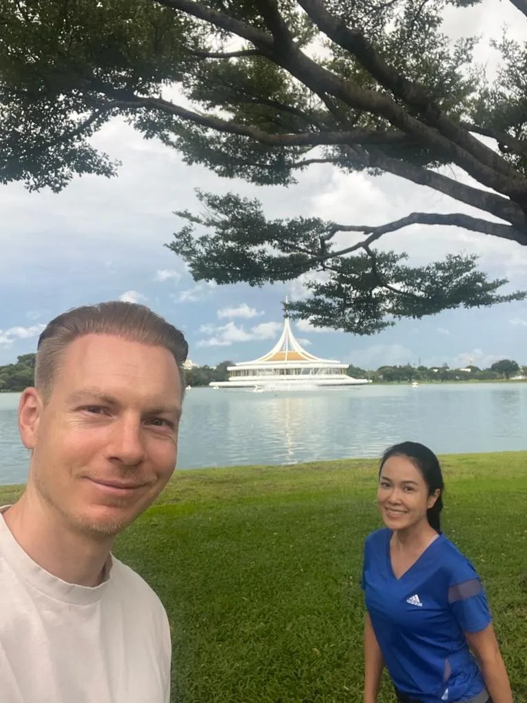 Ein junges Paar vor dem großen Museum im Rama IX Park in Bangkok mit dem See im Hintergrund